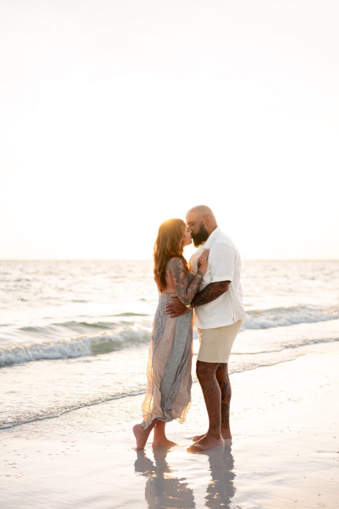 Parents embracing at sunset shoreline during Bean Point Beach family photos on Anna Maria Island