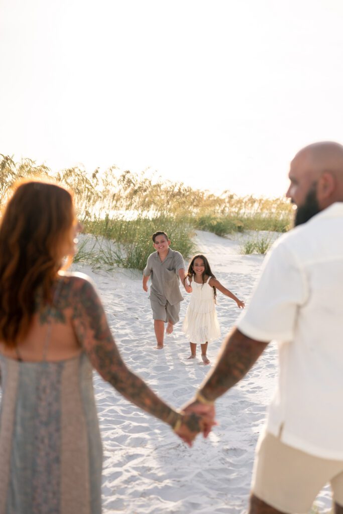 Children running toward parents during Bean Point Beach family photography session on Anna Maria Island