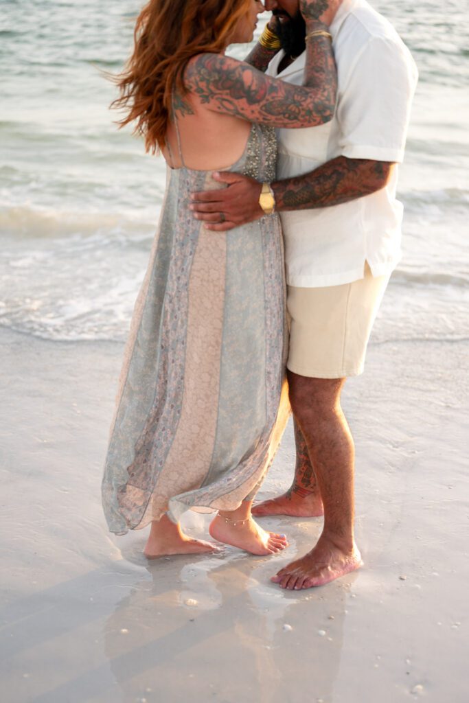 Parents embracing at shoreline during Bean Point Beach family photos on Anna Maria Island