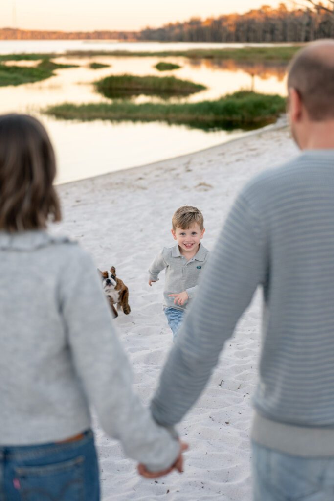 Lake Louisa State Park family photography session with child running on sandy lakeshore at sunset