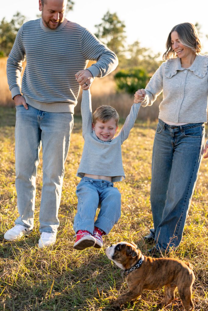 Lake Louisa State Park family photos with parents playing with child in golden hour outdoor setting