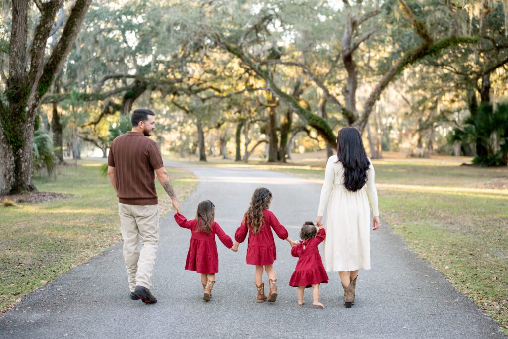 Family walking together during Moss Park Orlando family photography session under oak trees in natural light