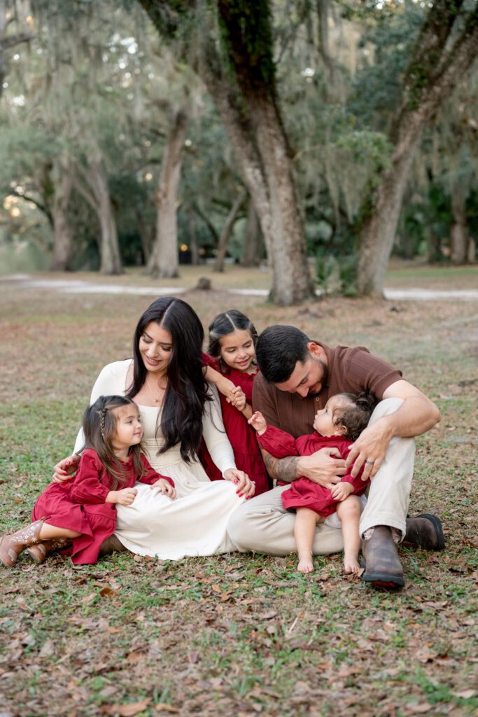 Family portraits at Moss Park Orlando FL with parents and children sitting together outdoors during golden hour