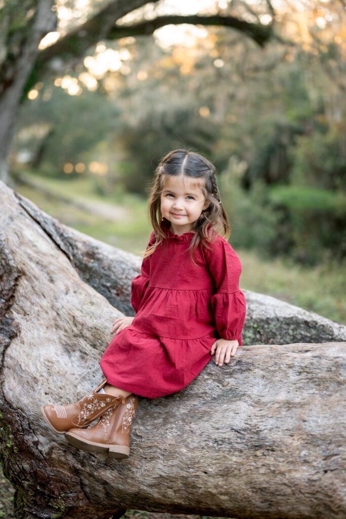 Child portrait sitting on tree during Moss Park family portraits Orlando Florida outdoor session