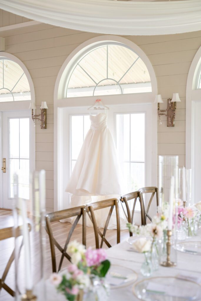 Bridal gown hanging in light-filled reception space at Summit on Cross Mountain Jefferson NC