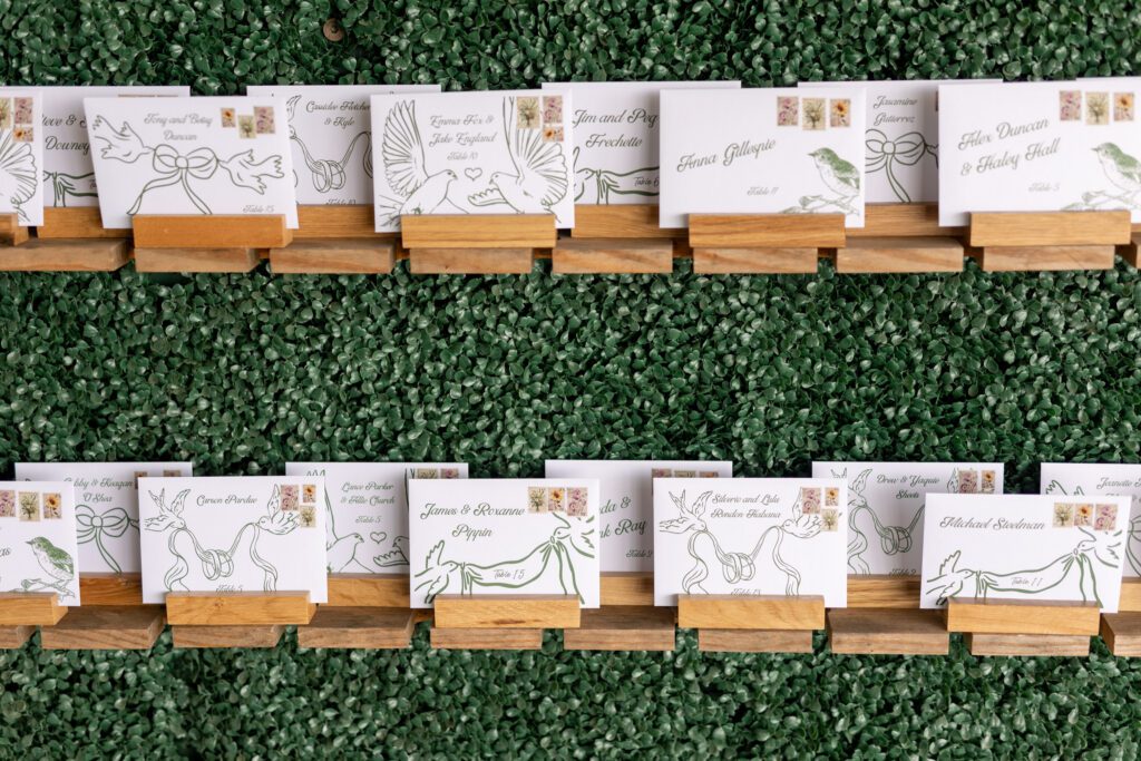 Wedding escort card display with greenery wall at NC mountain wedding venue in Jefferson North Carolina