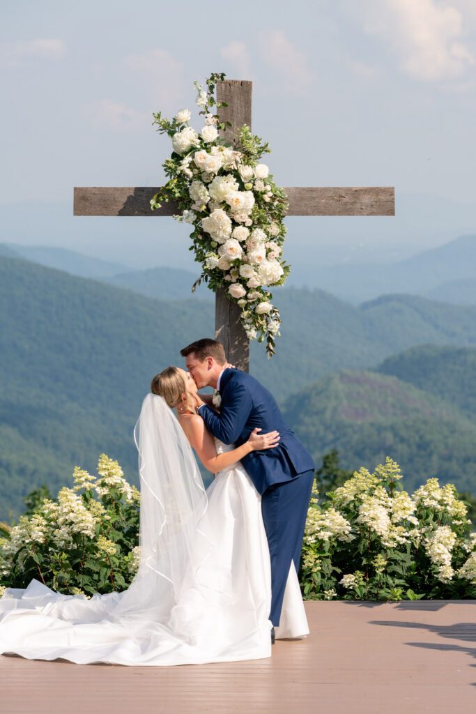 Summit on Cross Mountain Jefferson NC wedding ceremony with couple kissing at mountain overlook venue