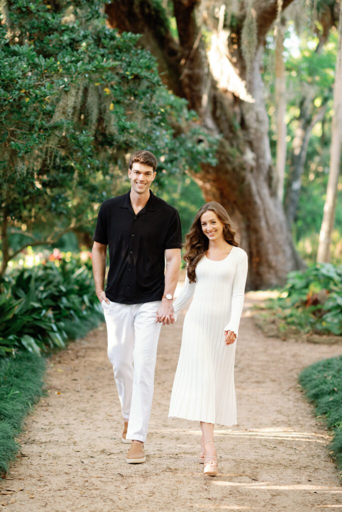 Couple walking beneath oak trees during a Washington Oaks Gardens State Park engagement session in Palm Coast, Florida