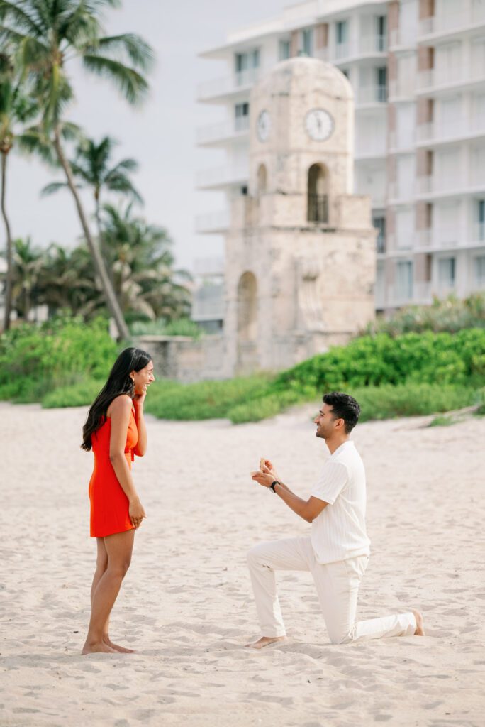 Surprise proposal at the Worth Avenue Clock Tower in Palm Beach, Florida with groom down on one knee during a romantic beachside moment