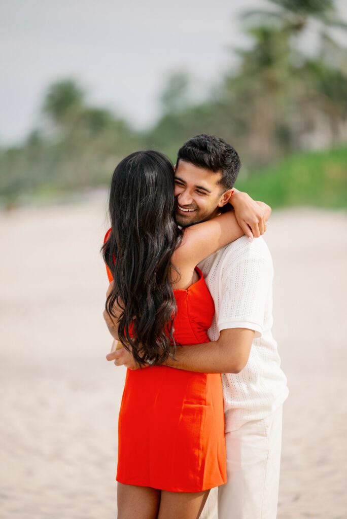 Joyful couple embracing on the beach after a Worth Avenue Clock Tower proposal in Palm Beach, Florida